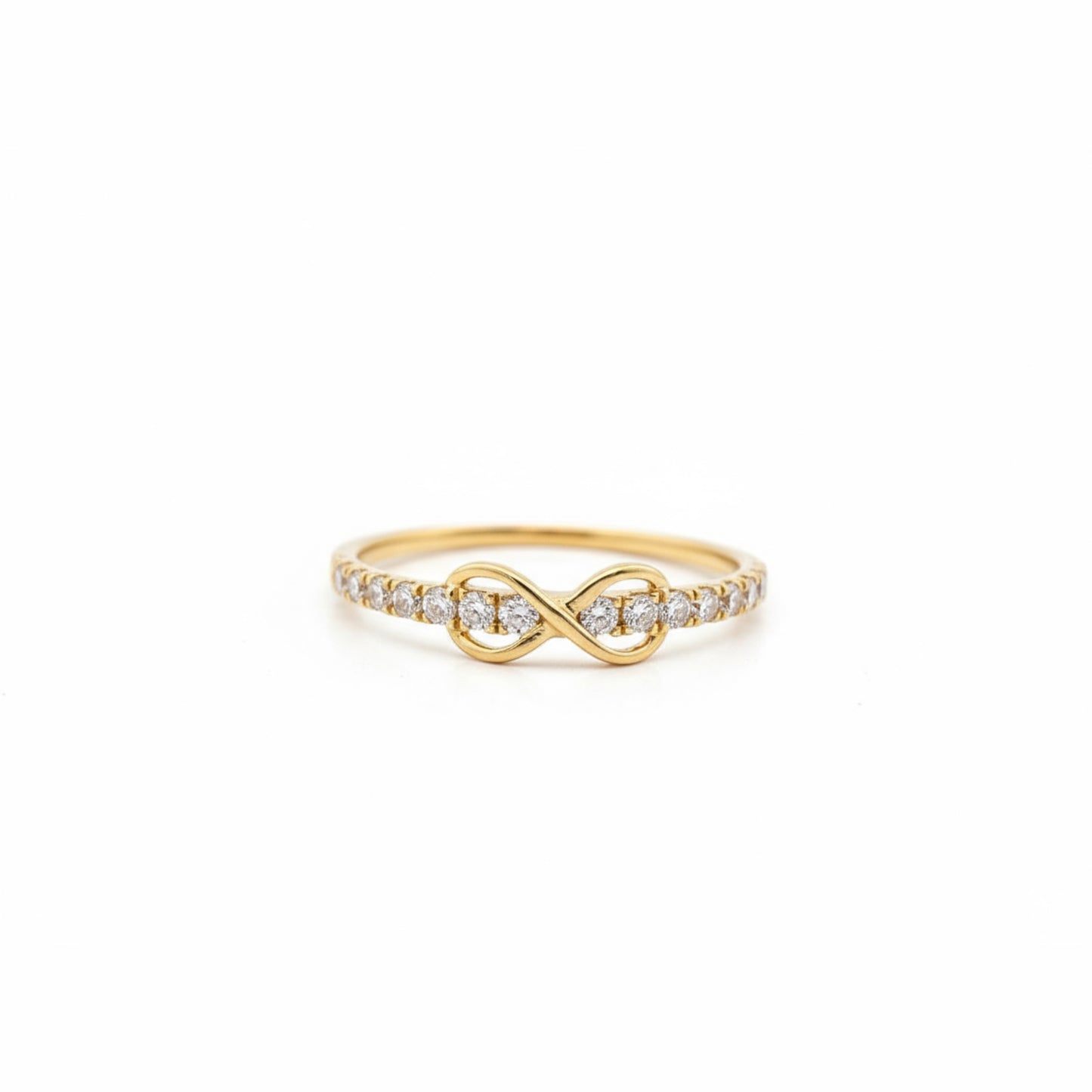 Gold infinity ring with diamonds on a white background